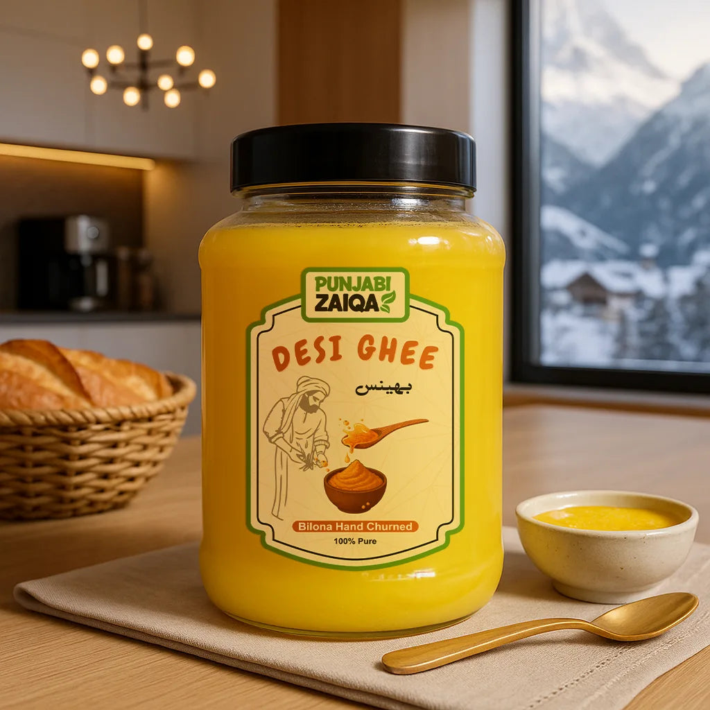 Jar of Punjabi Zaiqa buffalo Desi Ghee on a table with a bowl and spoon in a kitchen setting.